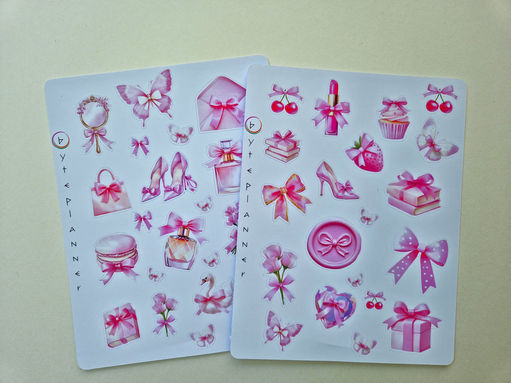 Zwei Stickerbögen im Format 13 × 17 cm mit romantischen pastellrosa Motiven (Schleifen, Parfumflakon, Geschenkboxen, Cupcake, Erdbeere, Kirschen, Blumen und Schmetterlinge) auf weißem Hintergrund