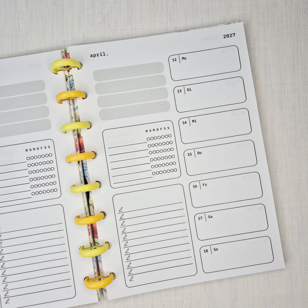 Zwei nebeneinanderliegende Planer-Einlagenseiten im minimalistischen Grau-Beige-Design mit der Überschrift WOCHE AUF 1 SEITE. Links eine Wochenübersicht ‘meine woche.’ mit Boxen für Mo–So und kleinen Datumsfeldern; rechts die Fortsetzung derselben Woche mit Boxen für Mo–So und dem Monatskopf ‘januar’ sowie Jahreszahl ‘2027’. In beiden Seiten gibt es zusätzlich neutrale Platzhalterfelder, einen kleinen Habit-Tracker mit Kreisen und einen linierten Notiz-/To-do-Bereich. Am Rand sind Lochungen/Discs-Markierung
