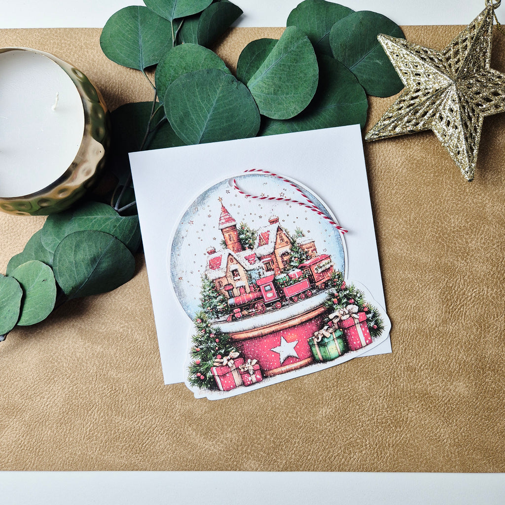 Weihnachtskarte mit Schneekugel-Motiv und Anhänger