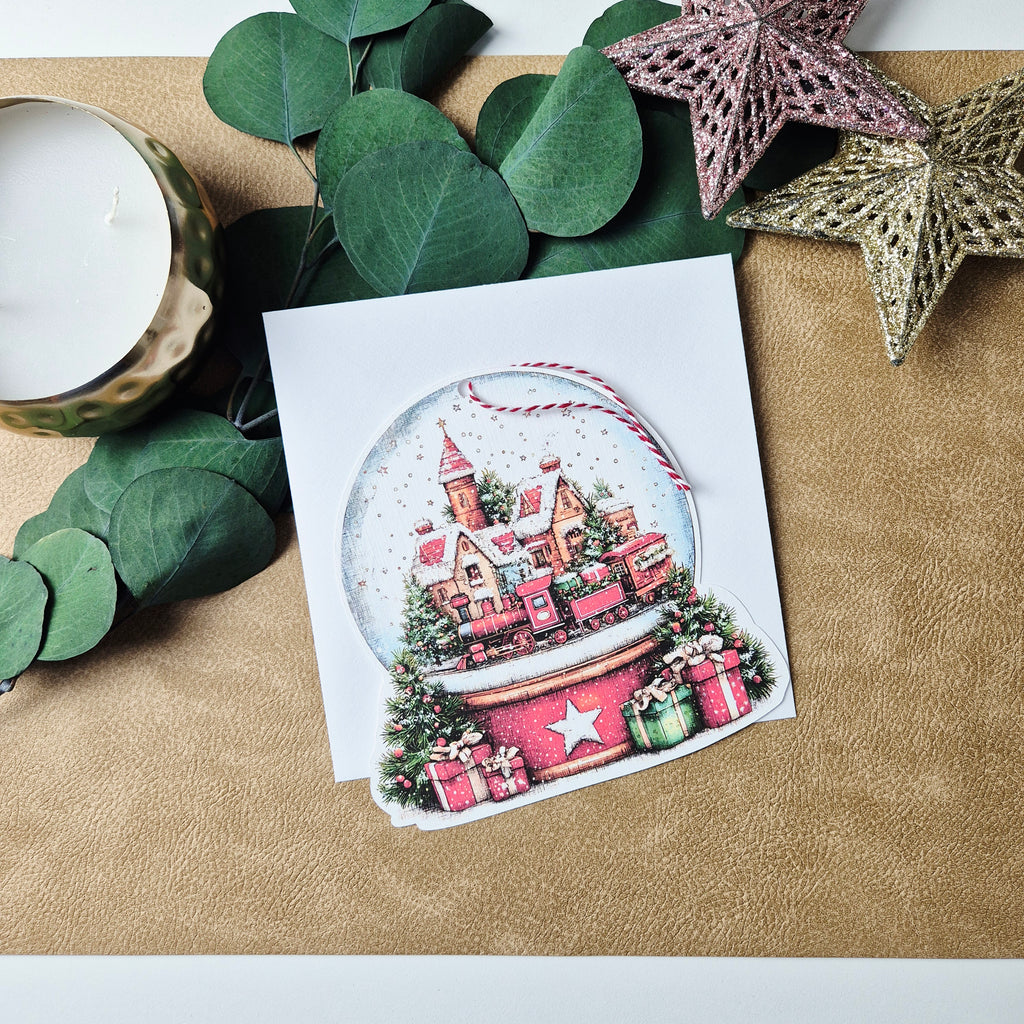 Weihnachtskarte mit Schneekugel-Motiv und Anhänger