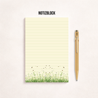 Schmaler, linierter Notizblock im Hochformat mit cremefarbenem Papier, feinen Linien und einer Blumenwiese mit kleinen Bienen am unteren Rand