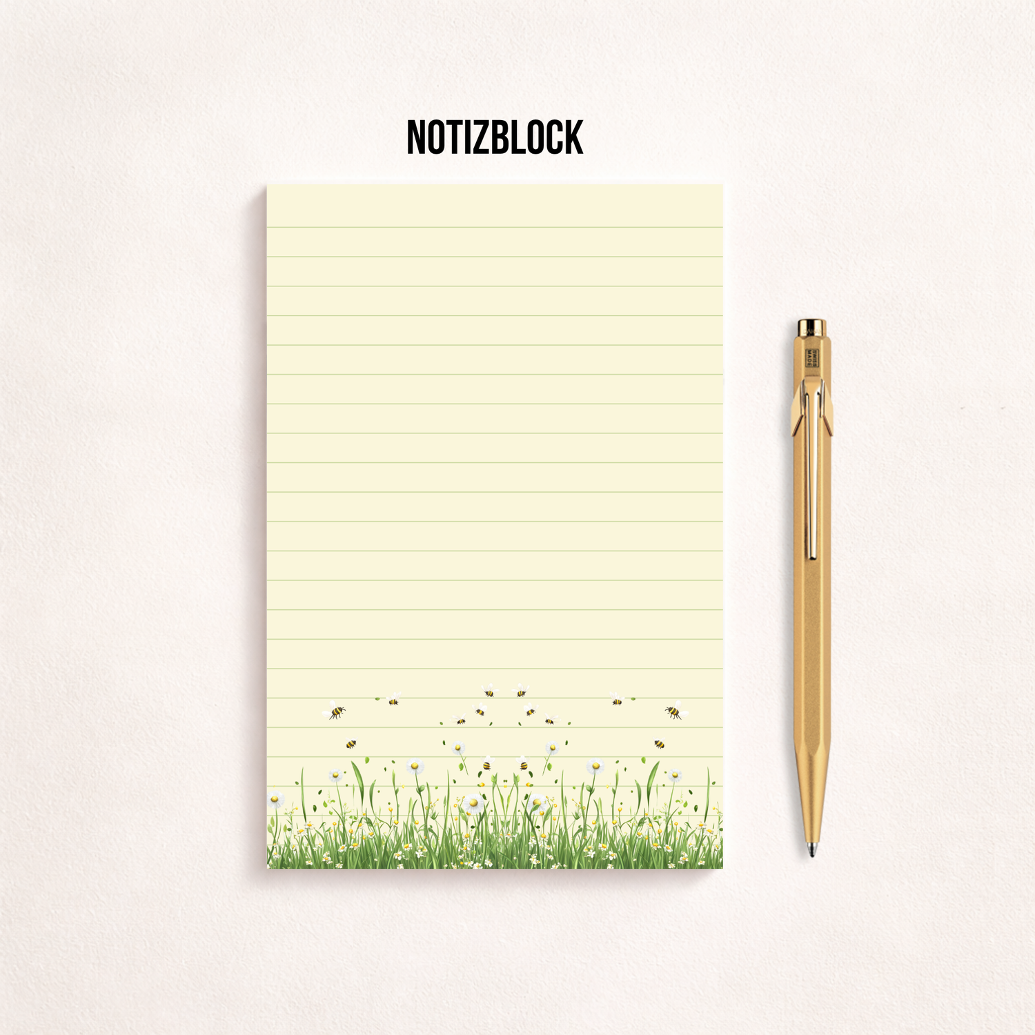 Schmaler, linierter Notizblock im Hochformat mit cremefarbenem Papier, feinen Linien und einer Blumenwiese mit kleinen Bienen am unteren Rand