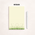 Schmaler, linierter Notizblock im Hochformat mit cremefarbenem Papier, feinen Linien und einer Blumenwiese mit kleinen Bienen am unteren Rand