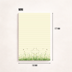 Schmaler, linierter Notizblock im Hochformat mit cremefarbenem Papier, feinen Linien und einer Blumenwiese mit kleinen Bienen am unteren Rand