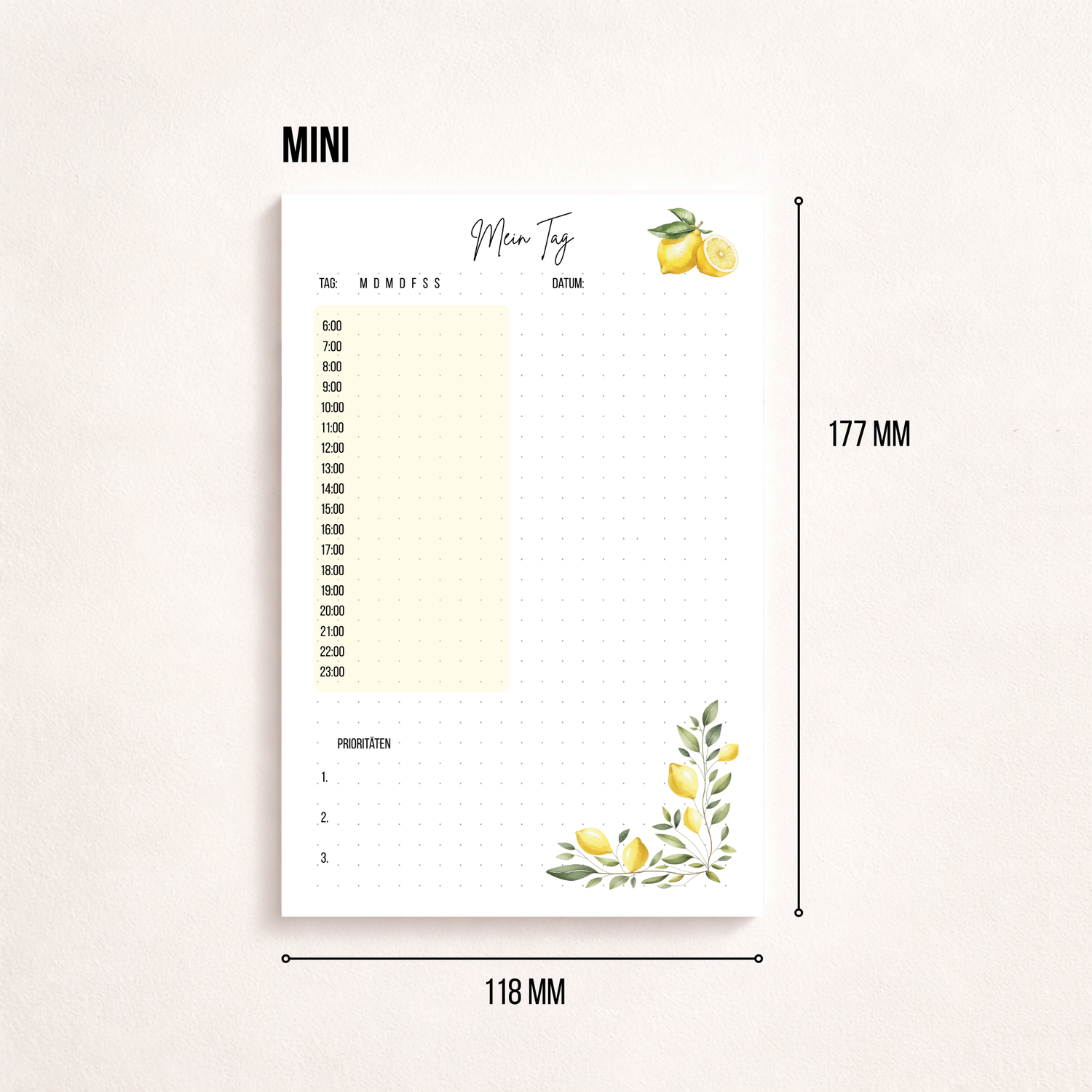 Minimalistischer Notizblock ‚Mein Tag‘ mit Zitronenmotiv, Tagesplan von 6 bis 23 Uhr, Datumsfeld und drei Prioritäten, fotografiert neben einem goldfarbenen Stift auf hellem Hintergrund.