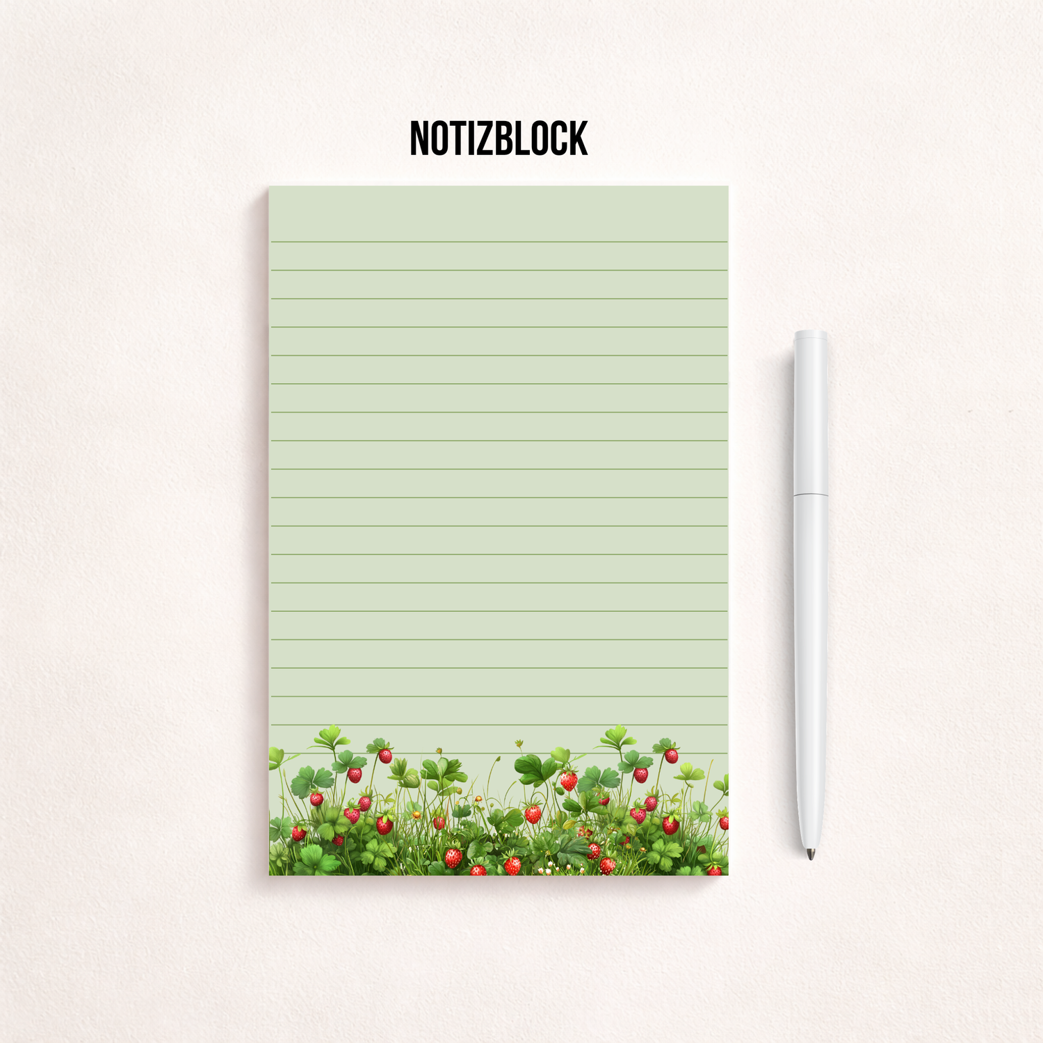 Liniertes Notizpapier im Hochformat mit grün-rosa Erdbeerwiesen-Motiv am unteren Rand, fotografiert auf dunkelgrauem Hintergrund. Links daneben liegt ein transparenter Stift parallel zum Block. Cleanes, minimalistisches Flatlay mit viel freiem Raum