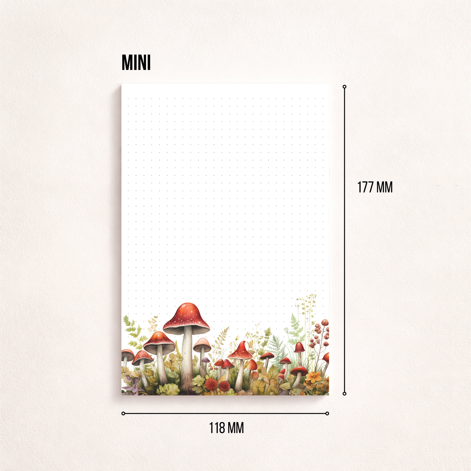 Weißes Notizblatt im Hochformat mit feinem Punktgitter und einer zarten Aquarell-Bordüre aus roten Pilzen, Blumen und Gräsern am unteren Rand