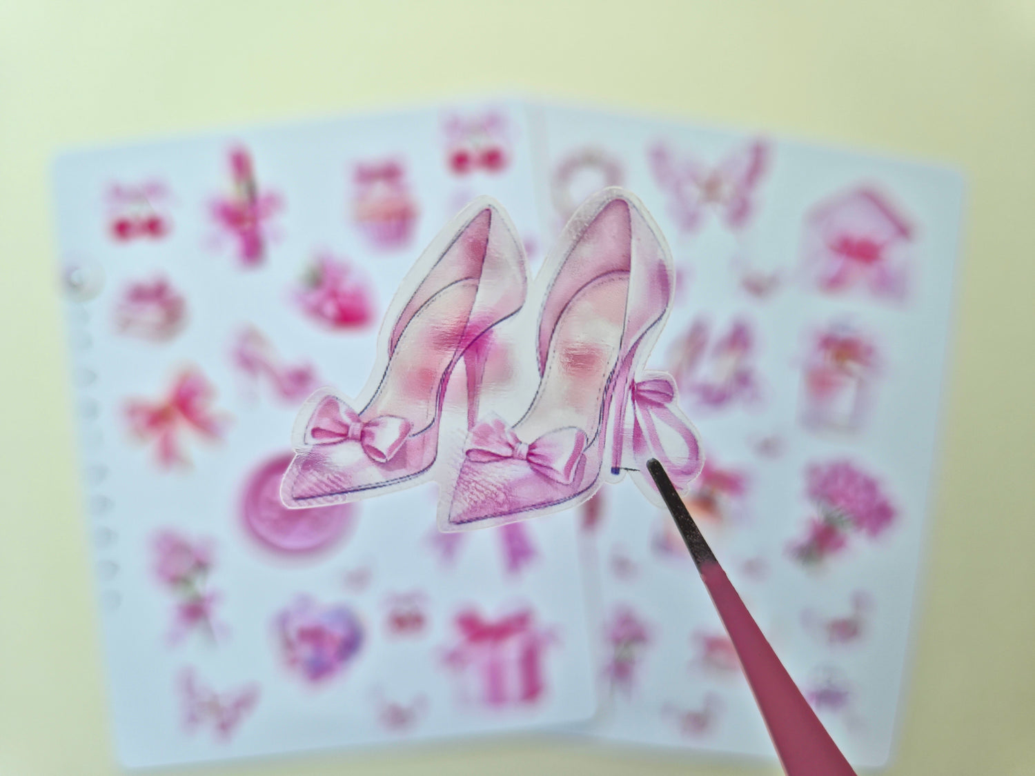 Zwei Stickerbögen im Format 13 × 17 cm mit romantischen pastellrosa Motiven (Schleifen, Parfumflakon, Geschenkboxen, Cupcake, Erdbeere, Kirschen, Blumen und Schmetterlinge) auf weißem Hintergrund