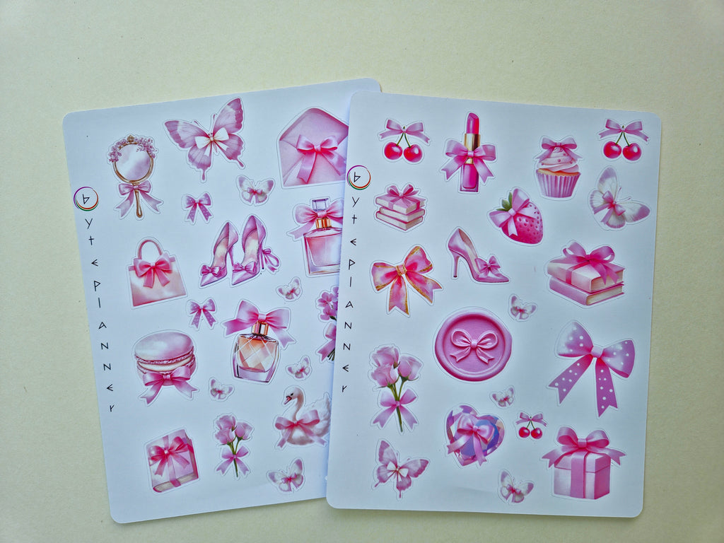 Zwei Stickerbögen im Format 13 × 17 cm mit romantischen pastellrosa Motiven (Schleifen, Parfumflakon, Geschenkboxen, Cupcake, Erdbeere, Kirschen, Blumen und Schmetterlinge) auf weißem Hintergrund